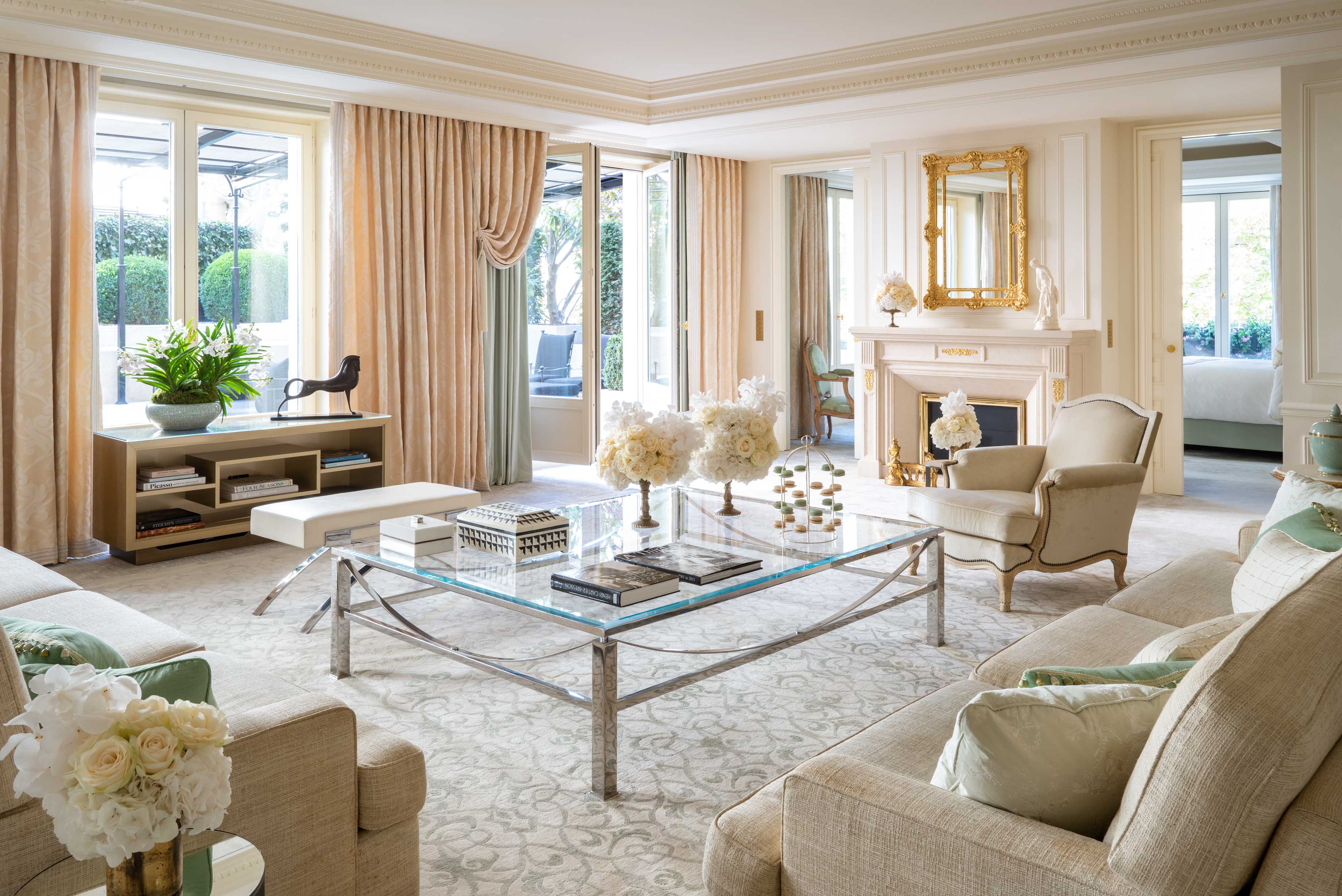 Salon lumineux d’une suite d’exception avec cheminée, mobilier élégant et grandes fenêtres